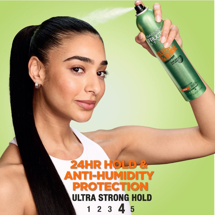 A model using Garnier Fructis Sleek & Shine hairspray, emphasizing its 24-hour hold and anti-humidity protection.